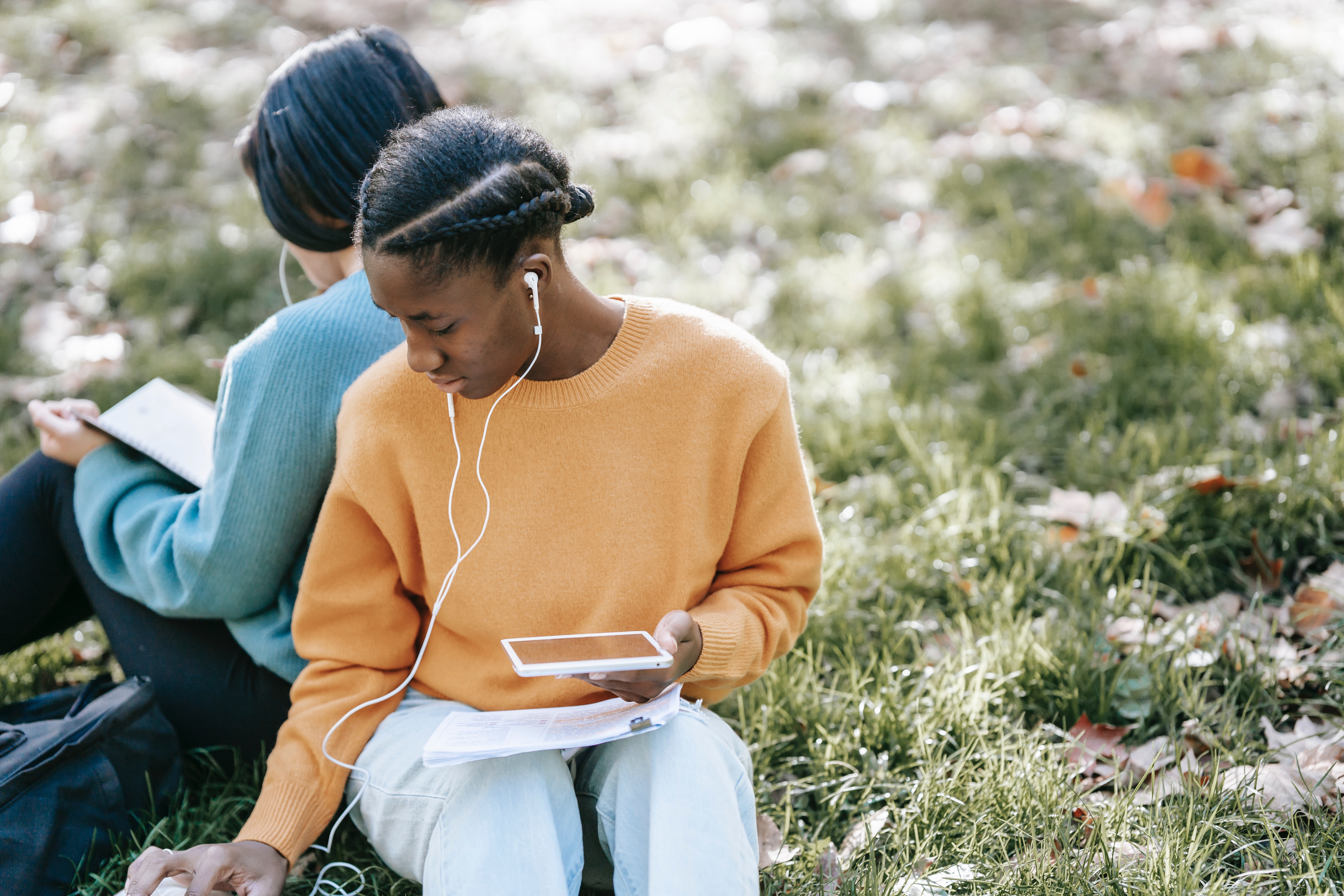 Ladies listening to a podcast on the grass