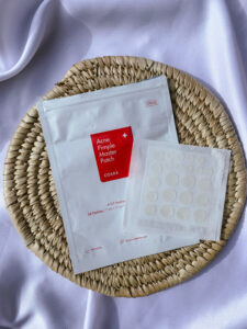 CosRx Acne pimple master patch on a rattan mat captured by Iruoma