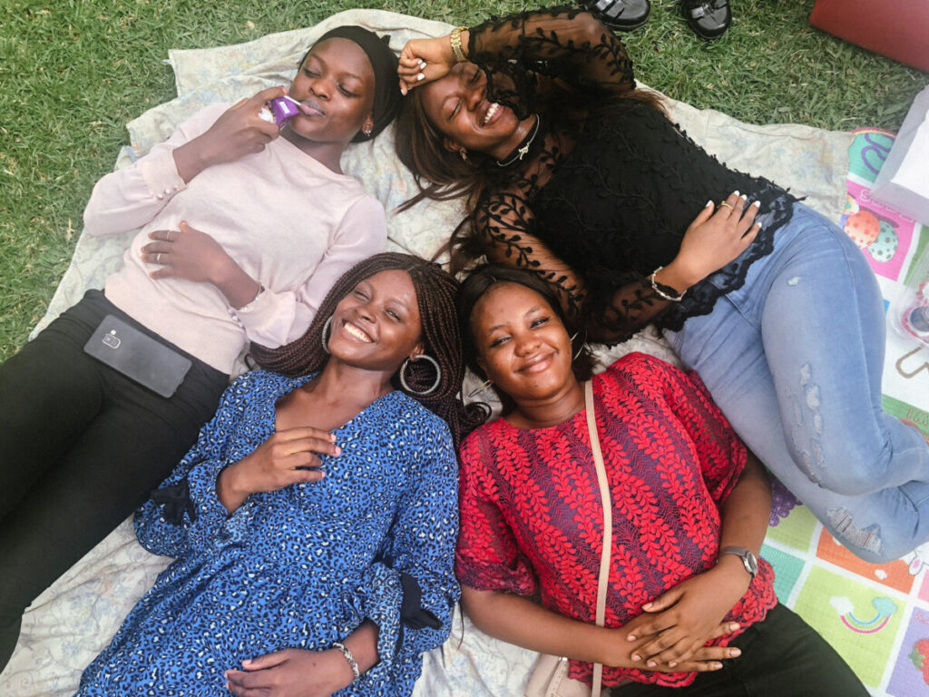 Iruoma and her friends laying on the grass at the ndubuisi kanu park