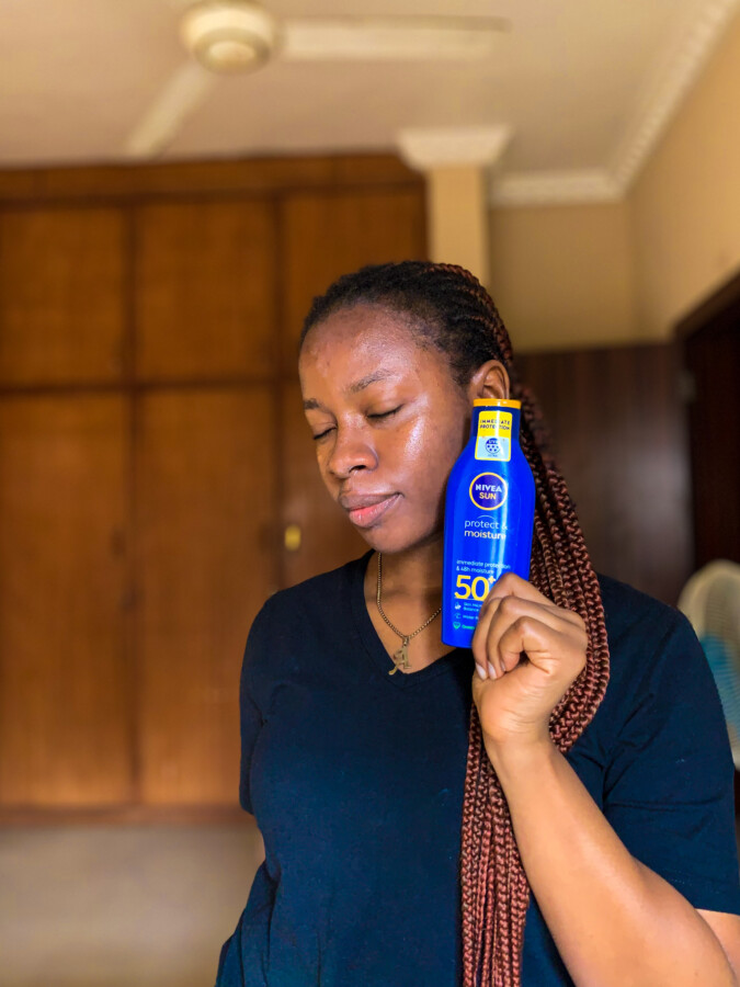 Nivea sun protect & moisture mineral sunscreen on Iruoma's left face